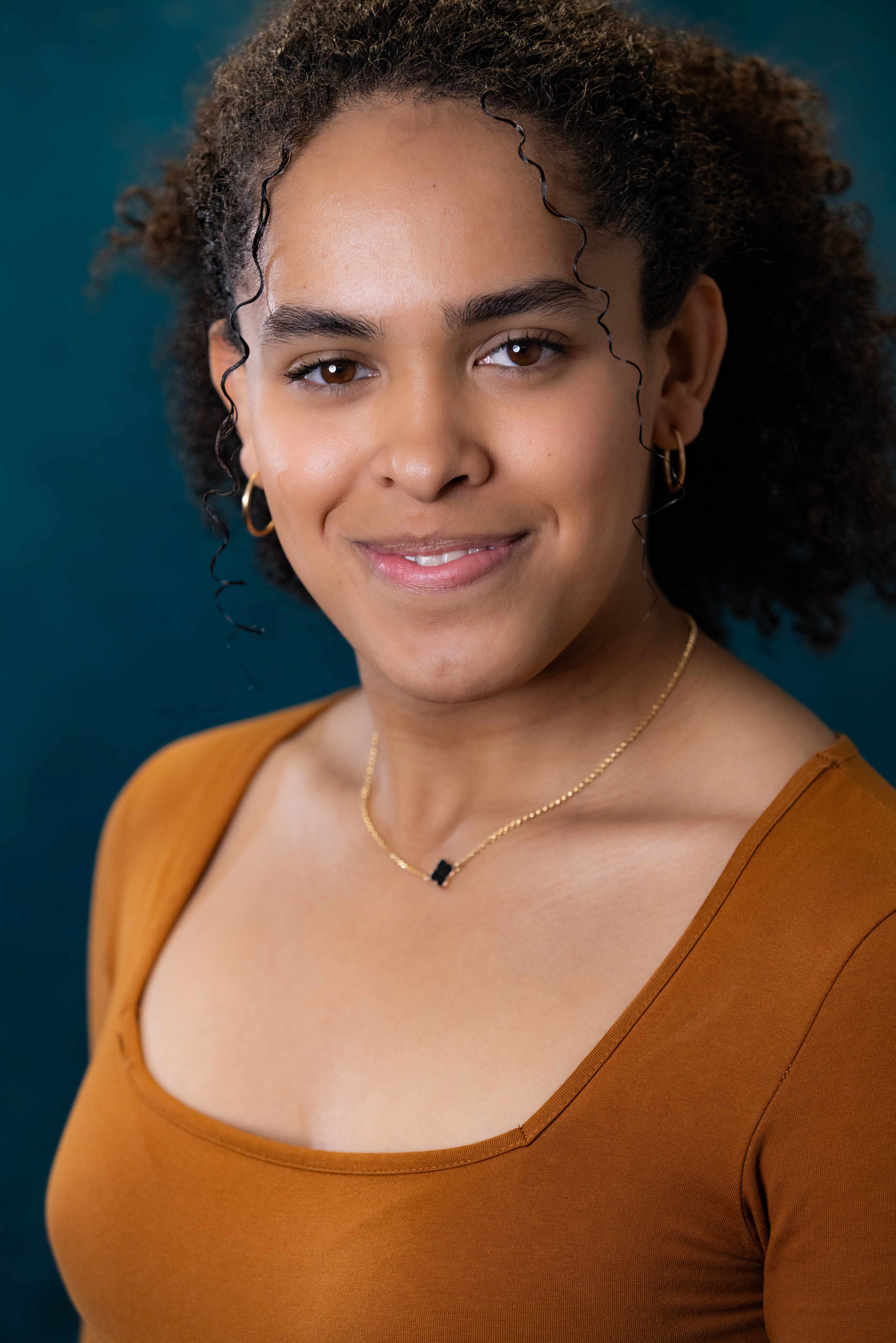 Professional headshot with teal background